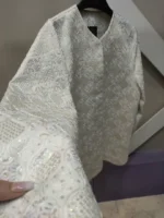 نمای نزدیک دوخت گل‌های سوزن‌دوزی شده روی کت کرم