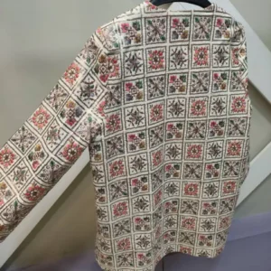 نمای پشت مانتو سوزن‌دوزی کرم با طرح موتیف رنگی و طراحی فری سایز زنانه