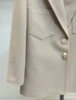 جزئیات جیب و یقه کت فوتر کرم رنگ زنانه