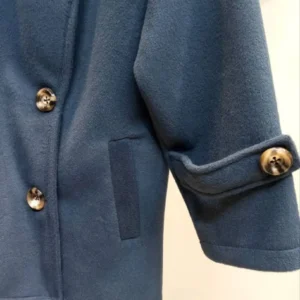 جزئیات کت پوست زنانه مدل یک‌طرفه رنگ آبی با طراحی شیک و تنخور آزاد