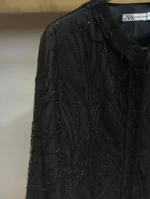 جزئیات دست‌دوزی ملیله روی توری مانتو مشکی