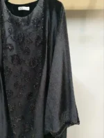 نمای نزدیک از بافت آستین تور روی مخمل مشکی با نگین‌های درخشان